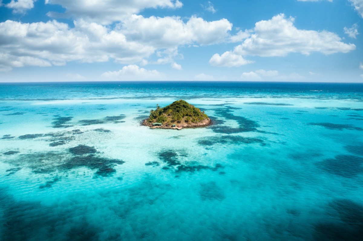 Una spiaggia bianca con acqua azzurra e un'isola lontana in lontananza