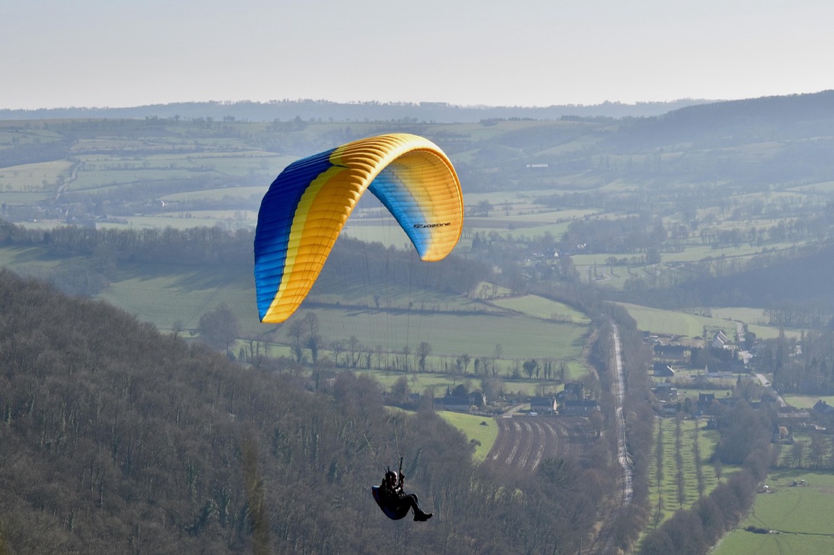 Paragliding over island with turquoise sea