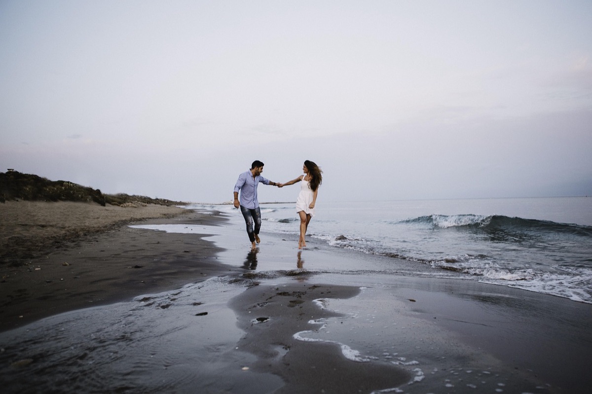 Couple walking on white sandy beach