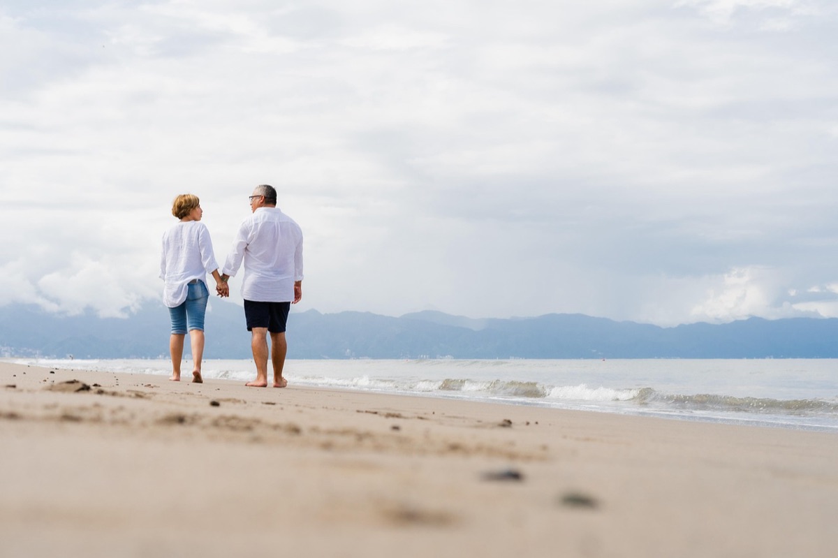 coppia che si stringe la mano sulla spiaggia
