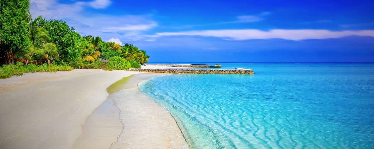 white sandy beach with colorful boats